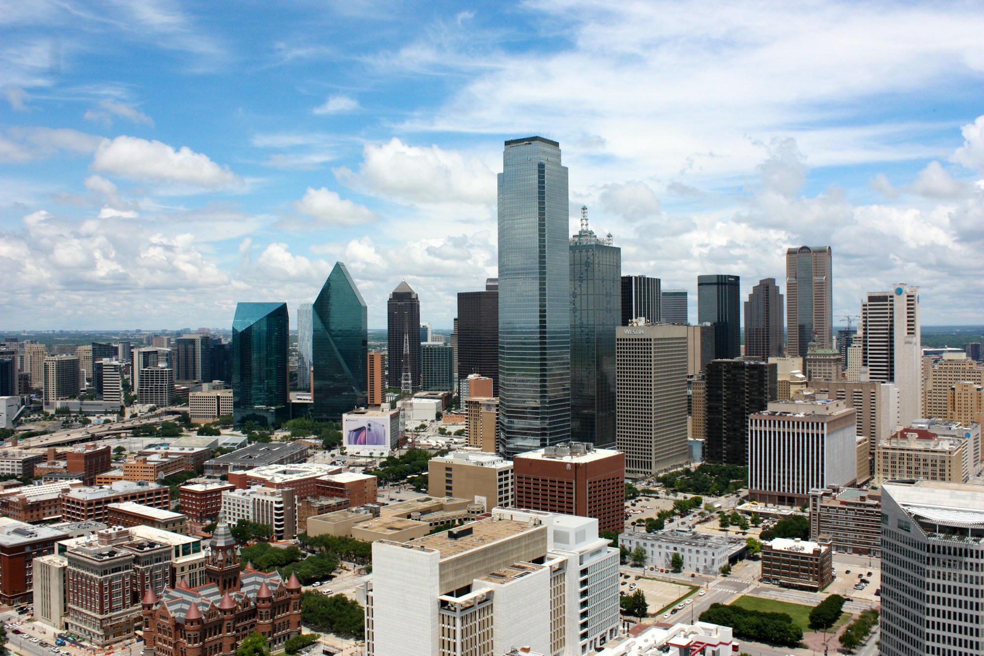 Downtown Dallas buildings under a bright cloudy sky